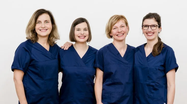 Die vier Fachärztinnen der Praxis in blauer Praxiskleidung